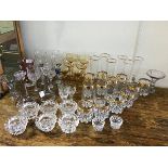 A mixed lot of mainly vintage stemmed glasses and beakers etc. together with vases, candlesticks,