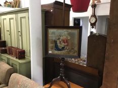 A 19th century mahogany pole screen of George III design, the needlework banner depicting a mother