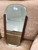 A 1960s teak framed wall mirror, the tapering detachable bevelled plate in a moulded 'sleeve', (58 x