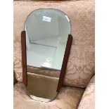 A 1960s teak framed wall mirror, the tapering detachable bevelled plate in a moulded 'sleeve', (58 x