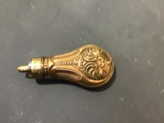 A embossed copper and brass pistol powder flask (l.11cm)