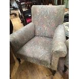 A late Victorian armchair, with floral upholstery, raised on tapering legs and castors (87cm wide)
