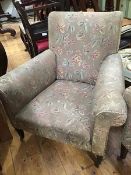 A late Victorian armchair, with floral upholstery, raised on tapering legs and castors (87cm wide)