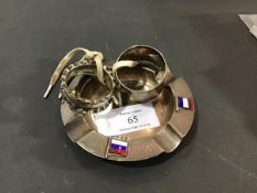 A silver ashtray with enamelled flags of the Allies, together with two metal napkin rings (3)
