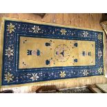 A Chinese wool rug, the central gold field with allover lotus leaf and flower decoration, floral