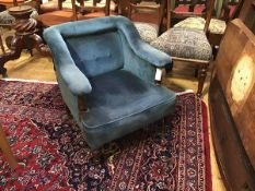 A Victorian walnut framed low armchair, the button-upholstered back enclosed by arms on turned