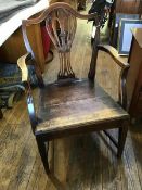 A George III oak country elbow chair c.1800, the shield-shaped back and pierced splat above a