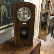 A 1940s walnut cased wall clock, the dome top case enclosing a silvered dial with arabic numerals,