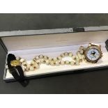 A mixed lot comprising a string of mother of pearl beads, a 9ct gold lady's wristwatch on black