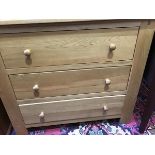 A modern light oak chest of three drawers, with turned handles and stile feet (85.5 x 98 x 48cm)