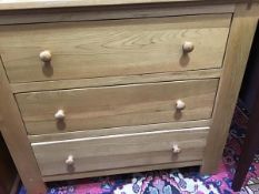 A modern light oak chest of three drawers, with turned handles and stile feet (85.5 x 98 x 48cm)