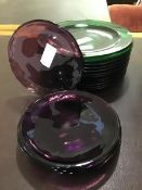 Thirteen green glass plates together with six amethyst coloured glass plates