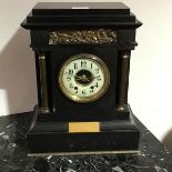 A black marble mantle clock, the rectangular stepped top with inset bronze panels depicting