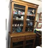 An Edwardian walnut cabinet bookcase, the top with a pair of glazed doors enclaong four adjustable