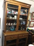 An Edwardian walnut cabinet bookcase, the top with a pair of glazed doors enclaong four adjustable