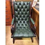 A modern mahogany and buttoned-leather library chair, with downswept arms and X-frame base (97cm