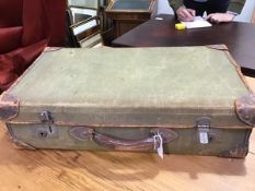 A vintage canvas covered suitcase containing various prints etc.