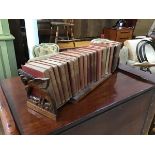 An Antipodean teak book shelf with carved bird ends enclosing a set of The Waverley Novels