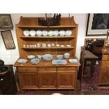 A Ercol modern elm Cotswold style dresser, the raised plate rack above three drawers and three