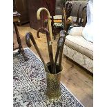 A circular embossed brass stick stand together with six walking sticks