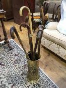 A circular embossed brass stick stand together with six walking sticks