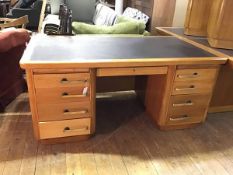 A 1940's oak pedestal desk by Abbess, the rectangular top with inset writing surface over a recess
