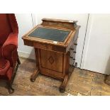 A late Victorian walnut and yew-wood banded Davenport, the raised top with hinged lid above a