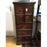 A modern narrow chest of four short and three long drawers, raised on a plinth base (118 x 49 x