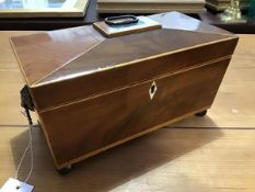 A 19thc mahogany and satinwood banded sarcophagus shaped tea caddy, the hinged top with brass