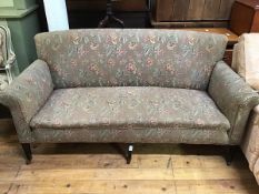 A late Victorian three-seat sofa, with floral upholstery, raised on tapering legs and castors (171cm