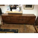 A 1960s teak sideboard by D. Meredew Ltd. the three cupboards and bank of four drawers with