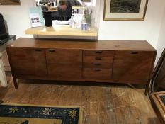 A 1960s teak sideboard by D. Meredew Ltd. the three cupboards and bank of four drawers with