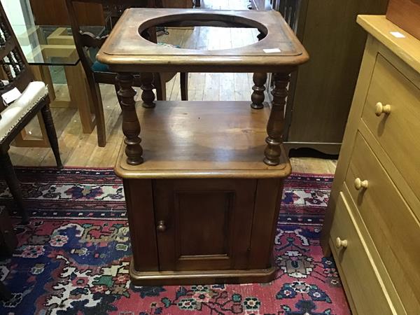 A Victorian mahogany basin stand, the raised recess above a panel door, raised on a plinth base (