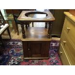 A Victorian mahogany basin stand, the raised recess above a panel door, raised on a plinth base (