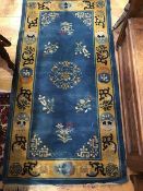 A Chinese wool rug, the centre panel with floral medallions, multiple flowerhead border (177cm x