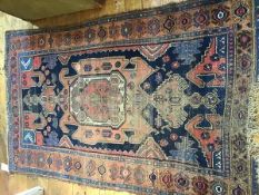 A 1920's Caucasian rug, the centre panel with geometric decoration, multiple flowerhead border (