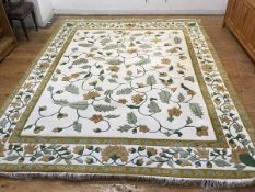 An Indian wool carpet, the central panel with allover leaf and flowerhead design, with multiple