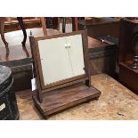 A 19thc. toilet mirror, the rectangular frame mirror on reeded supports, on rectangular base and