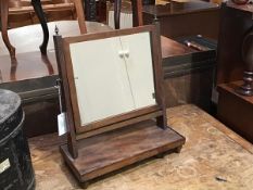 A 19thc. toilet mirror, the rectangular frame mirror on reeded supports, on rectangular base and
