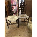 A pair of Edwardian oak ladderback side chairs with rush seats (h.93cm)