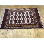 A finely knotted Bokhara rug, the central panel with three rows of six octagons, enclosed within a