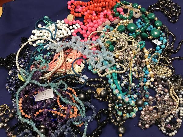 A mixed lot of beads and necklaces including glass, hardstone, mother of pearl, some with white