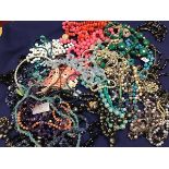 A mixed lot of beads and necklaces including glass, hardstone, mother of pearl, some with white