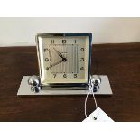 A 1930s chrome bedside clock on rectangular base with adjustable ball feet. (h.9cm)