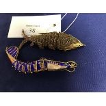 A gilt metal articulated filigree fish with inset green eyes (8cm), together with another