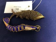 A gilt metal articulated filigree fish with inset green eyes (8cm), together with another