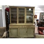A pine two part Estate kitchen dresser c.1900, the moulded top above three glazed sliding doors,