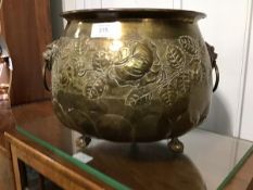 A Victorian brass jardiniere, the circular embossed body with lion mask handles, resting on ball and