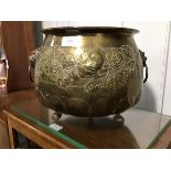 A Victorian brass jardiniere, the circular embossed body with lion mask handles, resting on ball and