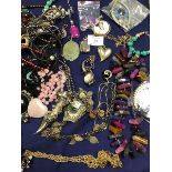 A collection of jewellery including pendants, brooches, hardstone beads, a white metal watch by